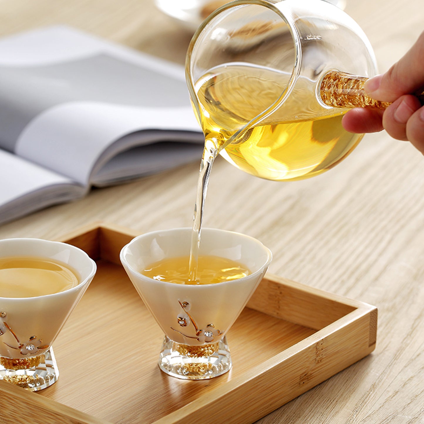 手拿分享喜樂茶具組的公道杯倒茶進入茶杯,公道杯的鷹嘴設計讓茶湯順暢出水,不會往其他地方滴漏